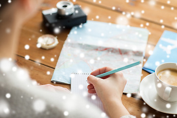 Image showing close up of traveler hands with notepad and pencil