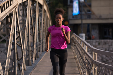 Image showing african american woman running across the bridge