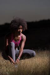 Image showing black woman runner tightening shoe lace