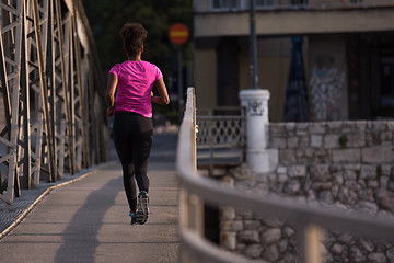 Image showing african american woman running across the bridge