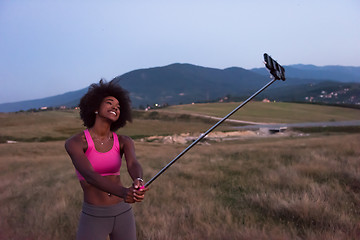 Image showing black woman photographing herself in nature