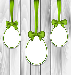 Image showing Easter three papers eggs wrapping green bows on grey wooden back