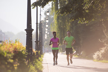 Image showing young multiethnic couple jogging in the city