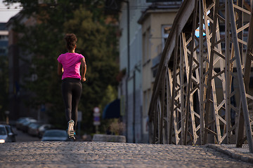 Image showing african american woman running across the bridge