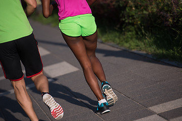 Image showing young smiling multiethnic couple jogging in the city