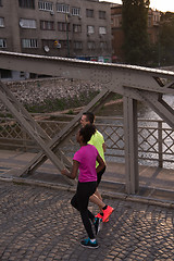 Image showing young multiethnic couple jogging in the city