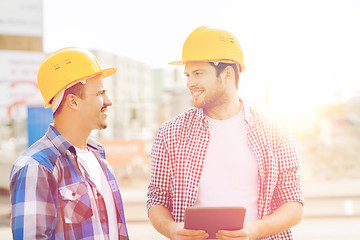 Image showing smiling builders with tablet pc outdoors