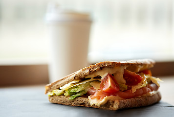 Image showing salmon panini sandwich on stone plate at cafe