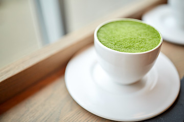 Image showing white cup of matcha green tea latte on table