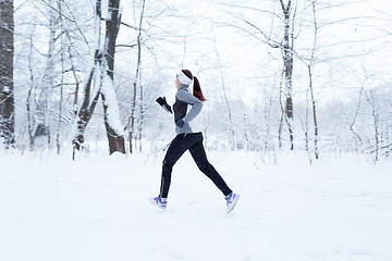 Image showing Woman running in winter woods
