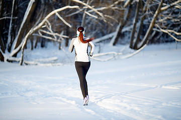 Image showing Female athlete on winter jogging