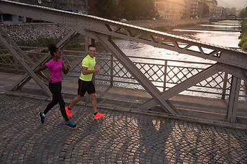 Image showing young multiethnic couple jogging in the city