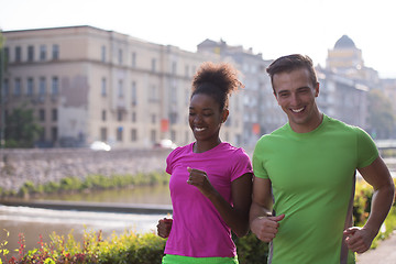 Image showing young multiethnic couple jogging in the city