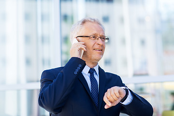 Image showing senior businessman calling on smartphone in city