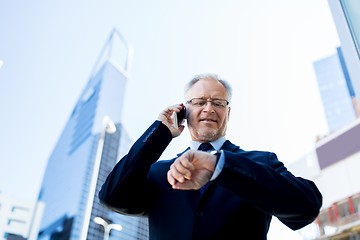 Image showing senior businessman calling on smartphone in city