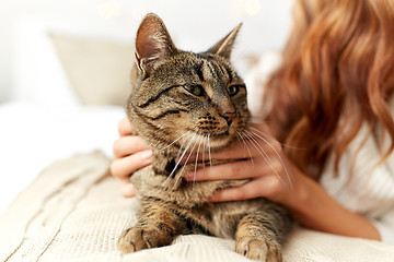 Image showing young woman with cat lying in bed at home