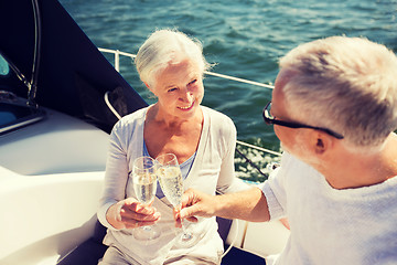 Image showing senior couple clinking glasses on boat or yacht