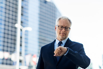 Image showing senior businessman checking time on his wristwatch