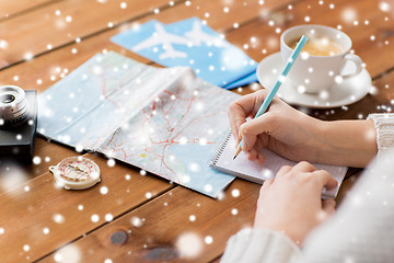 Image showing close up of traveler hands with notepad and pencil