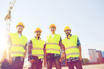 Image showing group of smiling builders with tablet pc outdoors