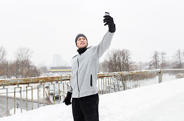 Image showing man taking selfie with smartphone in winter 