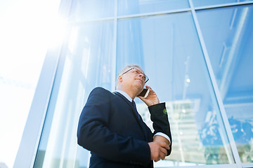 Image showing senior businessman calling on smartphone in city