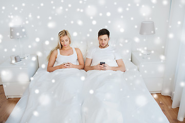 Image showing couple with smartphones in bed