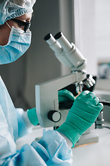 Image showing Crop hands putting microscope glasses in box