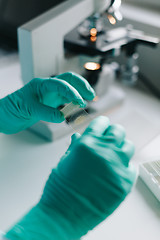 Image showing Crop hands putting microscope glasses in box