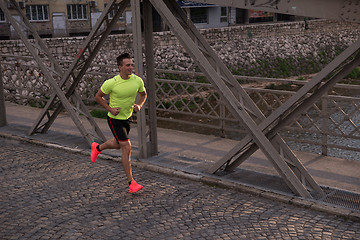 Image showing a young man jogging in the city