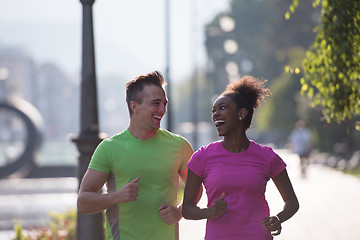 Image showing young multiethnic couple jogging in the city