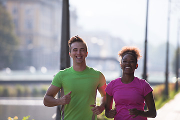 Image showing young multiethnic couple jogging in the city