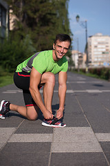 Image showing Young athlete, runner tie shoelaces in shoes