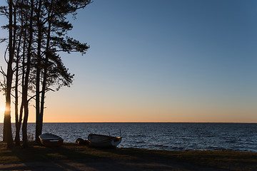 Image showing Sunset with rowing boats by the coast