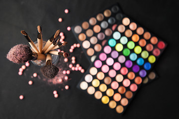 Image showing Palette of eyeshadows with brushes isolated on black background