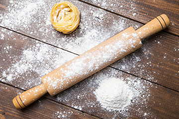 Image showing Wooden rolling pin with flour and pasta