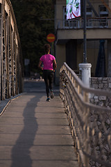 Image showing african american woman running across the bridge