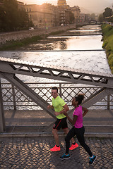 Image showing young multiethnic couple jogging in the city