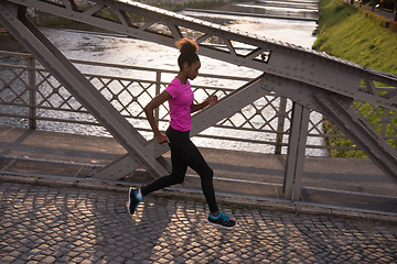 Image showing african american woman running across the bridge