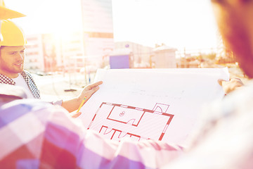 Image showing close up of builders with blueprint at building