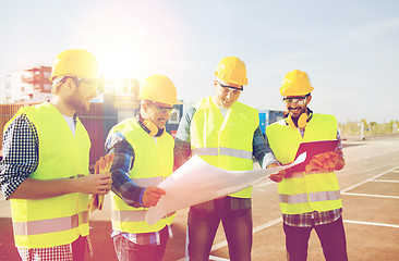 Image showing group of builders with tablet pc and blueprint