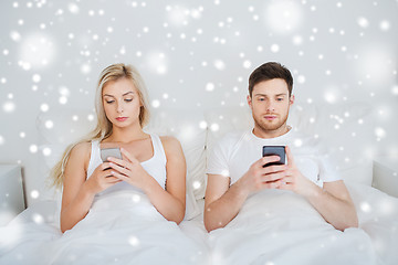 Image showing couple with smartphones in bed