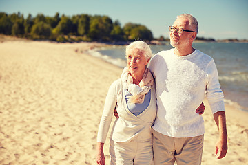 Image showing happy senior couple walking along summer beach