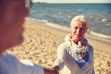 Image showing happy senior couple holding hands summer beach