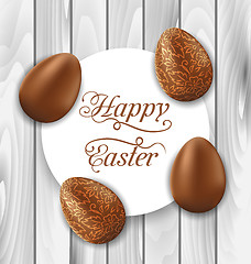 Image showing Greeting card with Easter chocolate ornamental eggs on wooden ba