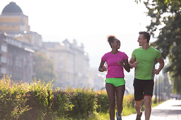 Image showing young multiethnic couple jogging in the city