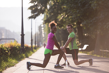 Image showing jogging couple warming up and stretching in the city