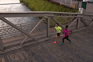 Image showing young multiethnic couple jogging in the city