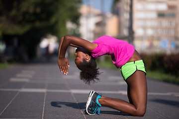 Image showing sporty young african american woman stretching outdoors