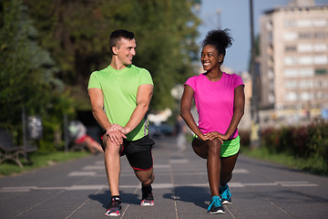 Image showing jogging couple warming up and stretching in the city